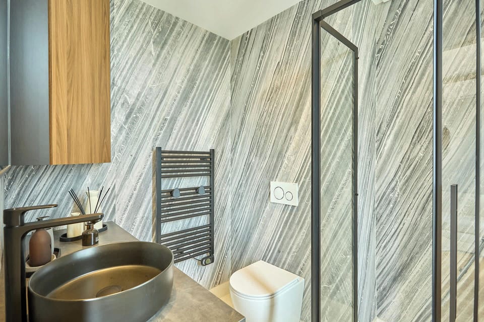 salle de bain avec douche, toilette et machine à laver séchante