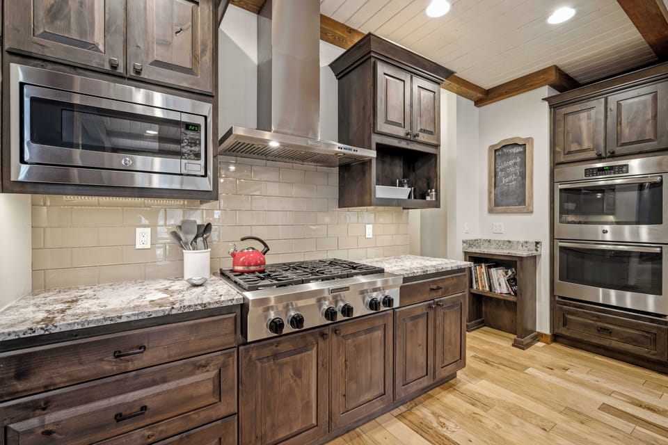 Your culinary dreams come true in this gourmet kitchen featuring granite countertops, premium appliances, and rustic wood cabinetry.