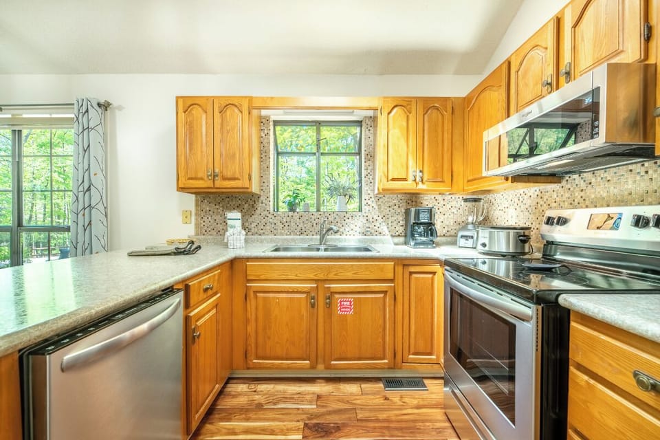 Your fully equipped kitchen awaits with warm wood cabinets, modern appliances, and everything you need for home-cooked meals during your stay.