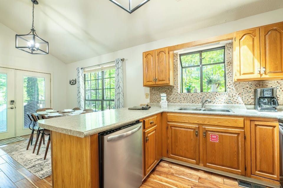 Gather around your spacious kitchen island for morning coffee or evening meals, with warm wood cabinets and natural light streaming through garden views.