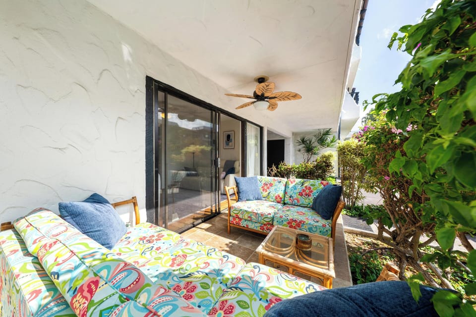Your private covered terrace with tropical-print seating where you can unwind with garden views and ceiling fan comfort.