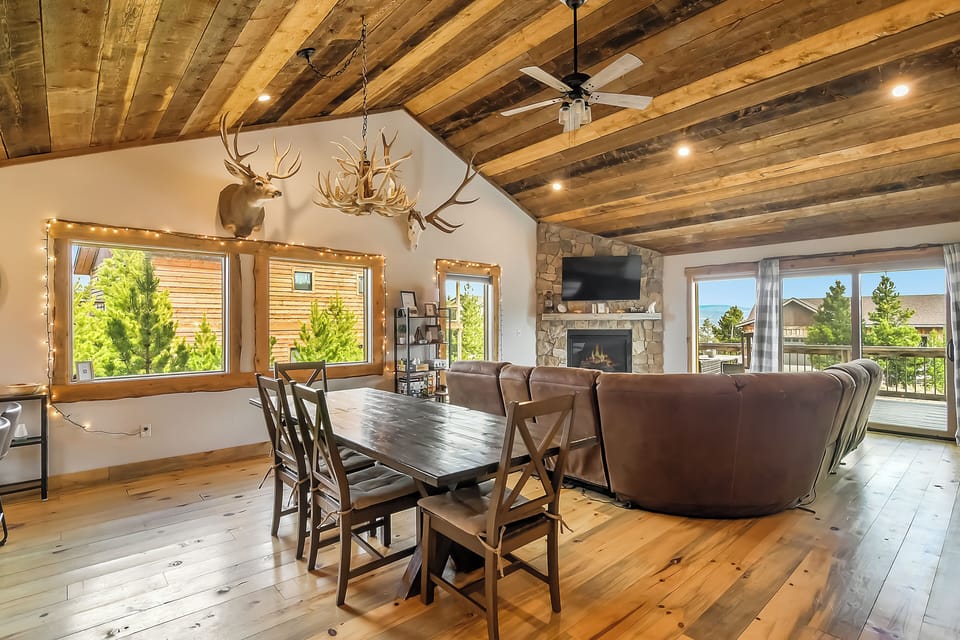 Cozy up in this rustic-chic living space where exposed beams and stone fireplace create the perfect mountain retreat atmosphere.
