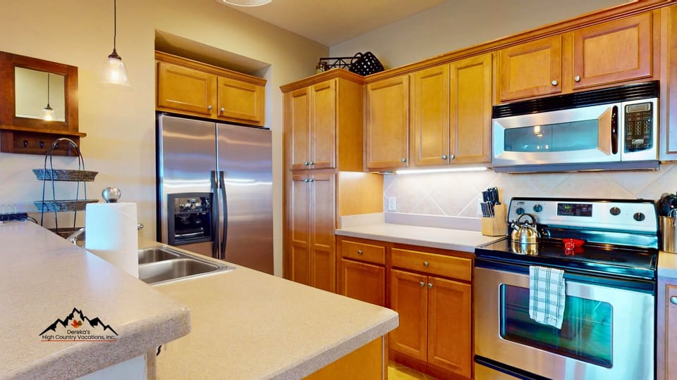 Your fully equipped kitchen features stainless steel appliances and a breakfast bar, perfect for preparing meals during your stay.
