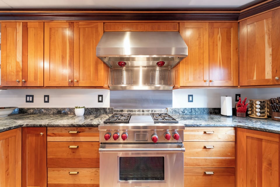 Your gourmet kitchen awaits with professional-grade appliances, granite countertops, and rich wood cabinetry perfect for creating memorable meals together.