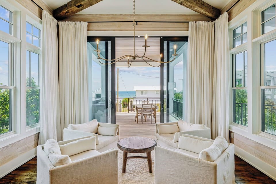 Sink into plush white seating beneath soaring beams while ocean breezes flow through your private terrace doors.