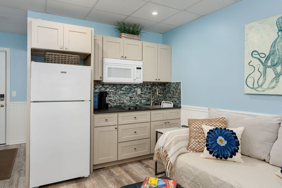 Your spacious kitchen features full-size appliances, soothing coastal colors, and a cozy living area perfect for preparing meals and relaxing.