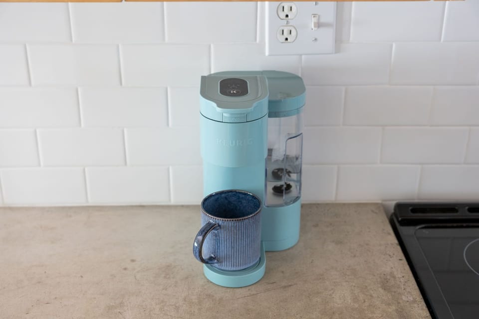Start your mornings right with this stylish single-serve coffee maker, perfectly positioned for your daily caffeine ritual in this modern kitchen.