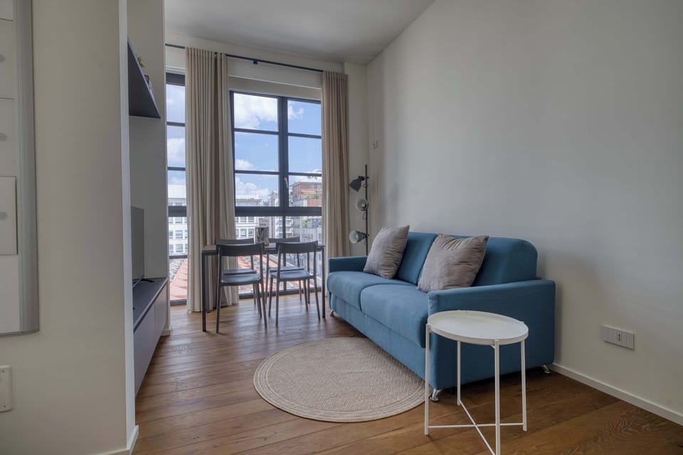 Modern living area with a comfortable sofa and TV, perfect for relaxing after a day in the city.

