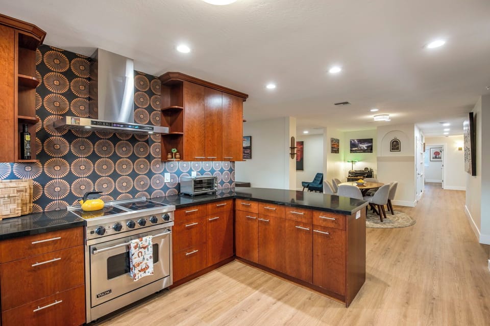 Bold patterned backsplash, warm wood cabinets, room to cook for a crowd.
