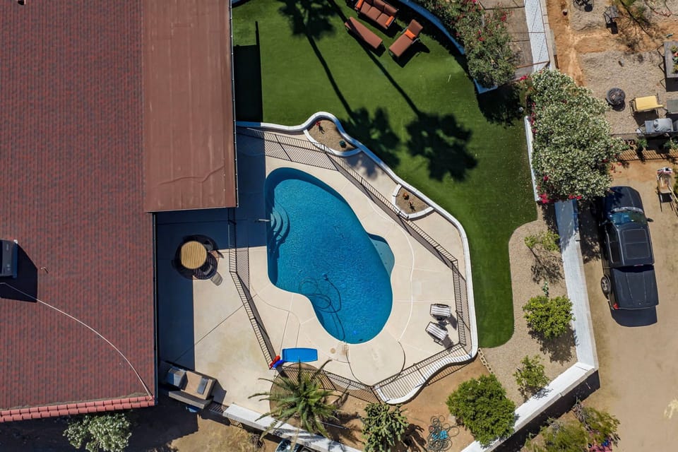 Kidney pool, sun shelf and turf lawn — the whole spread from above.
