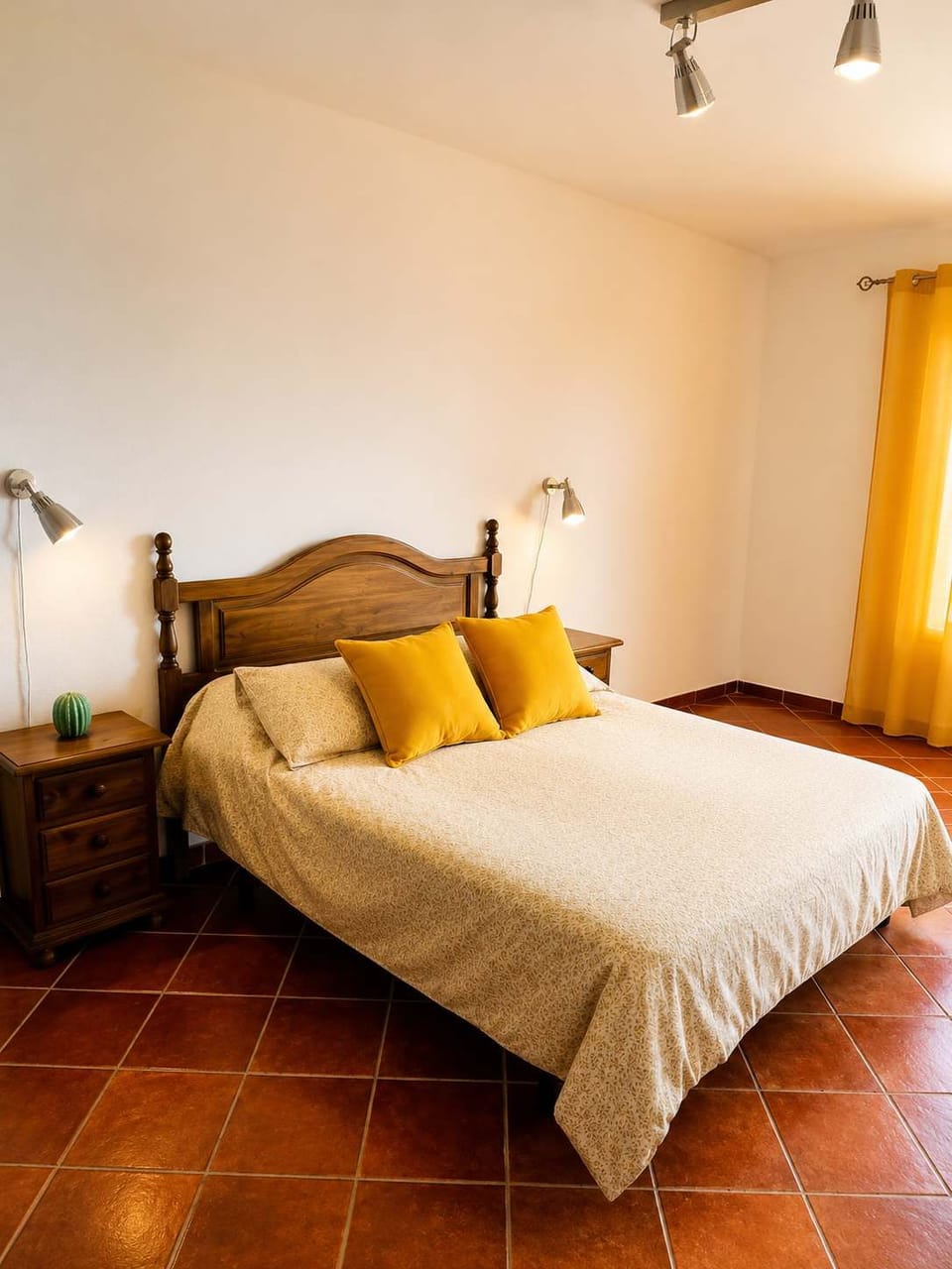 Dormitorio acogedor con cama doble y detalles en tonos cálidos.