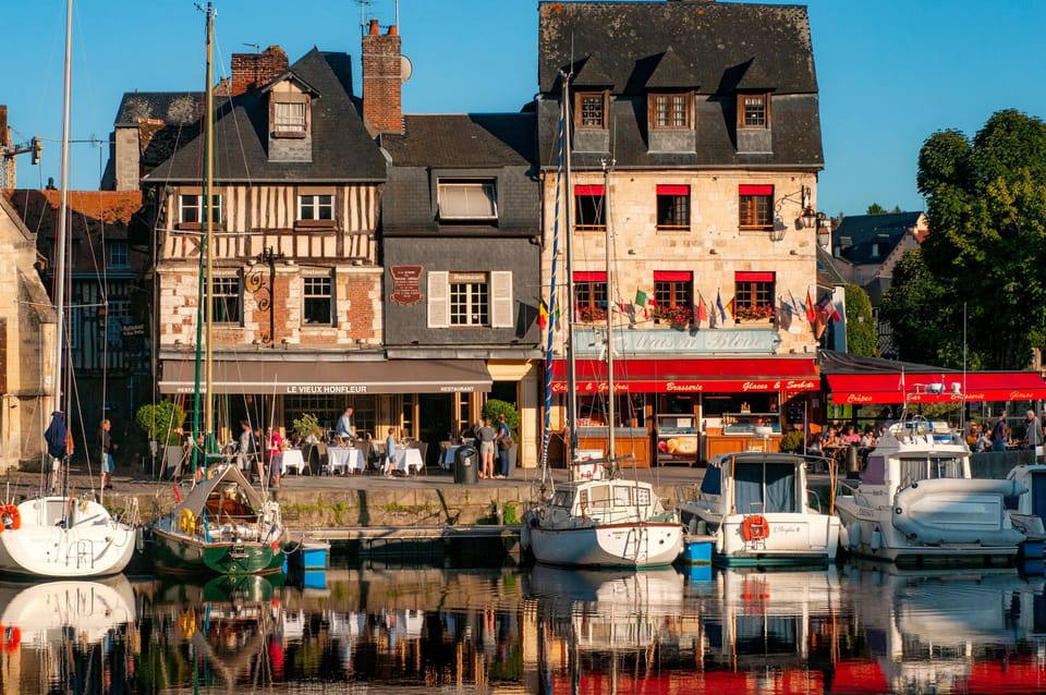 The old port at Honfleur — stone quays, moored boats, and centuries-old timber-framed houses