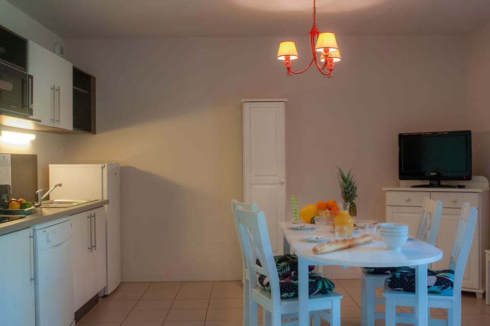 Kitchenette with ceramic hob, microwave, dishwasher, toaster, coffee maker, and kettle — everything for a full breakfast in