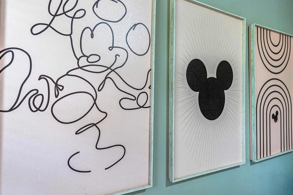 Modern framed wall art featuring abstract and iconic designs on a soft green wall.