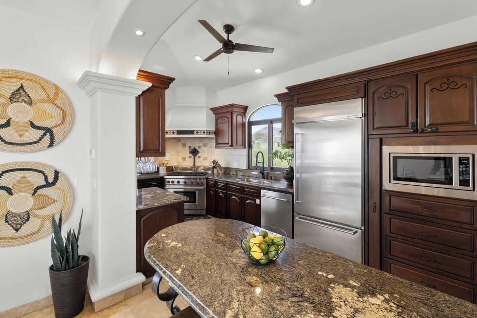 Fully equipped gourmet kitchen with granite countertops, custom wood cabinetry, and premium stainless steel appliances.