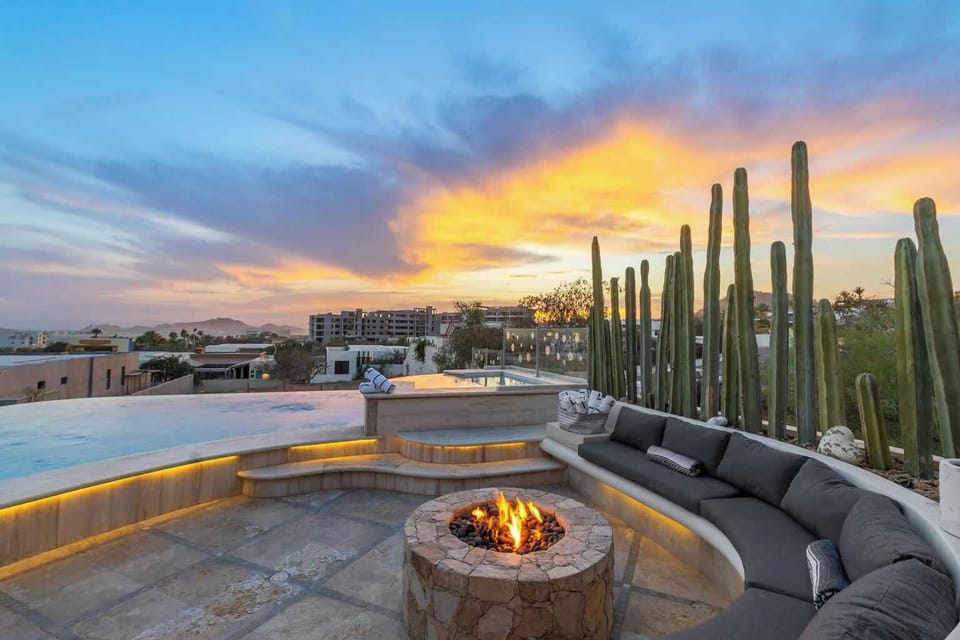 End the day at this breathtaking fire pit lounge, featuring curved seating and golden sunset views over the infinity pool and desert landscape.