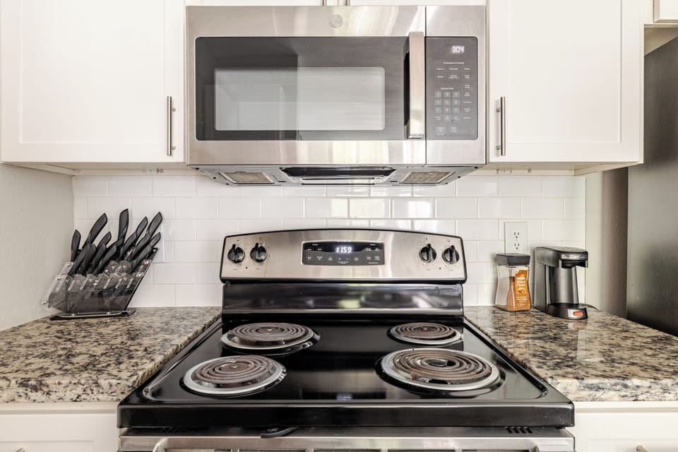 Bright kitchen with granite counters, coffee maker, and stainless appliances