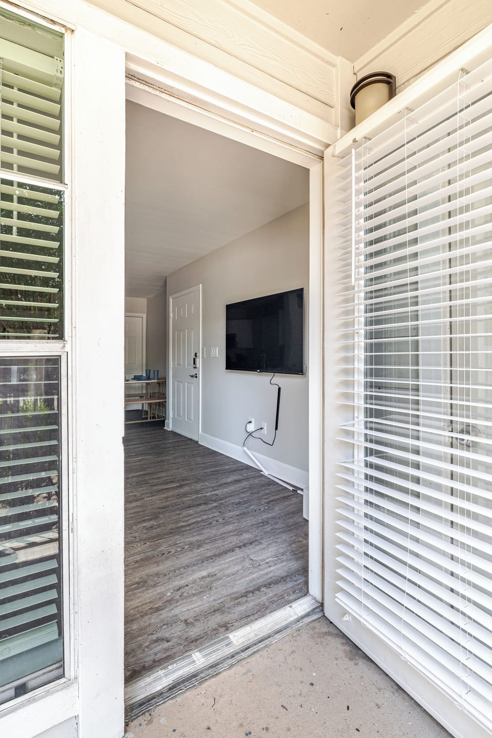 Private entry with bright interior, wood floors, and wall-mounted TV