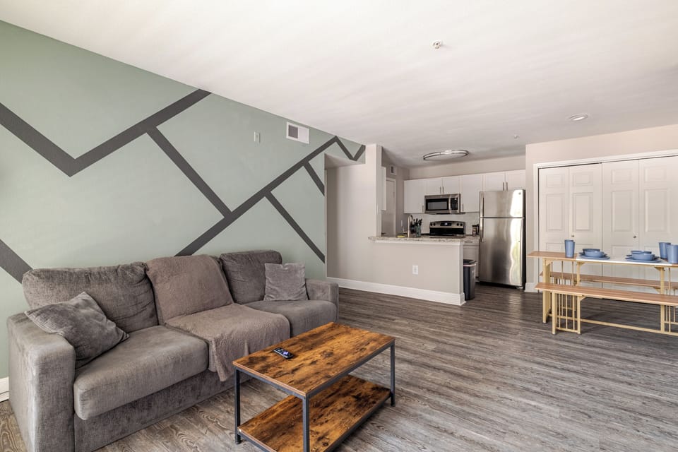 Open-concept living with stylish accent wall and modern kitchen