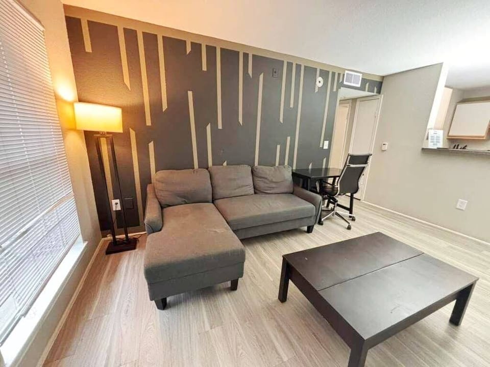 Modern lounge with stylish accent wall, workspace, and cozy seating
