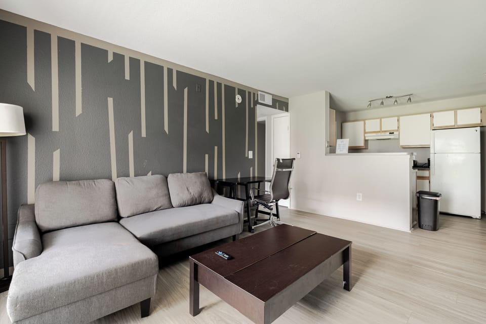 Modern open living room with stylish accent wall and breakfast bar