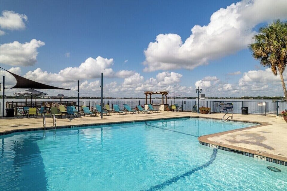 Waterfront pool deck with lounge seating and beautiful open sky views
