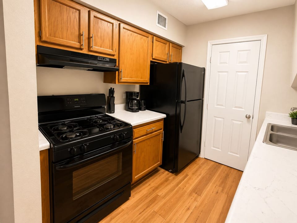 Bright galley kitchen with gas stove, coffee maker, and ample storage