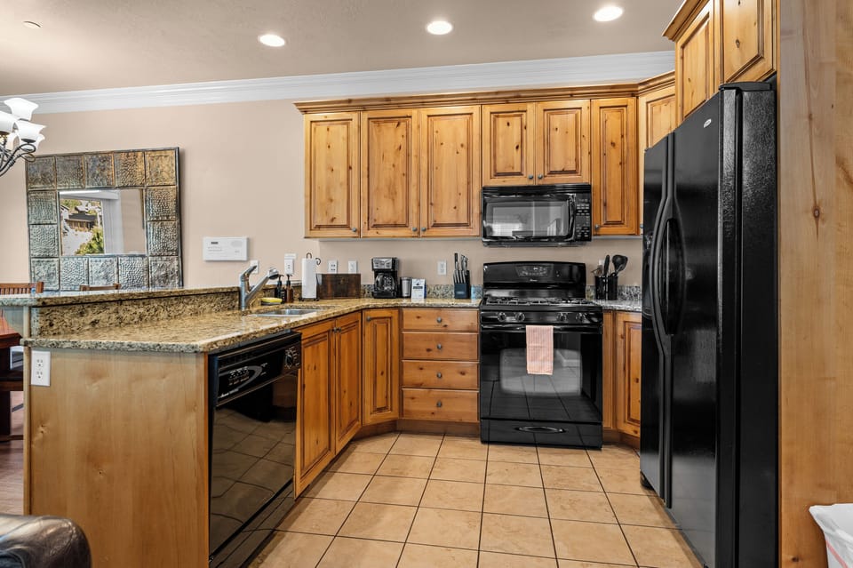 Fully equipped kitchen with granite countertops, modern appliances, and everything needed for home-cooked meals.