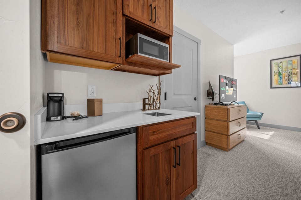 Convenient in-room kitchenette with mini fridge, microwave, and coffee setup.