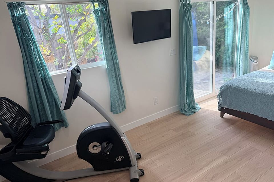 Bedroom, exercise area, view of backyard through sliders, TV