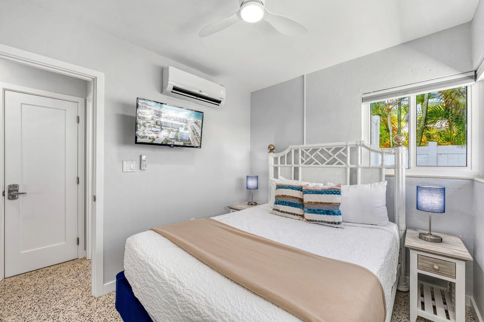 Comfortable queen bedroom with mounted TV.