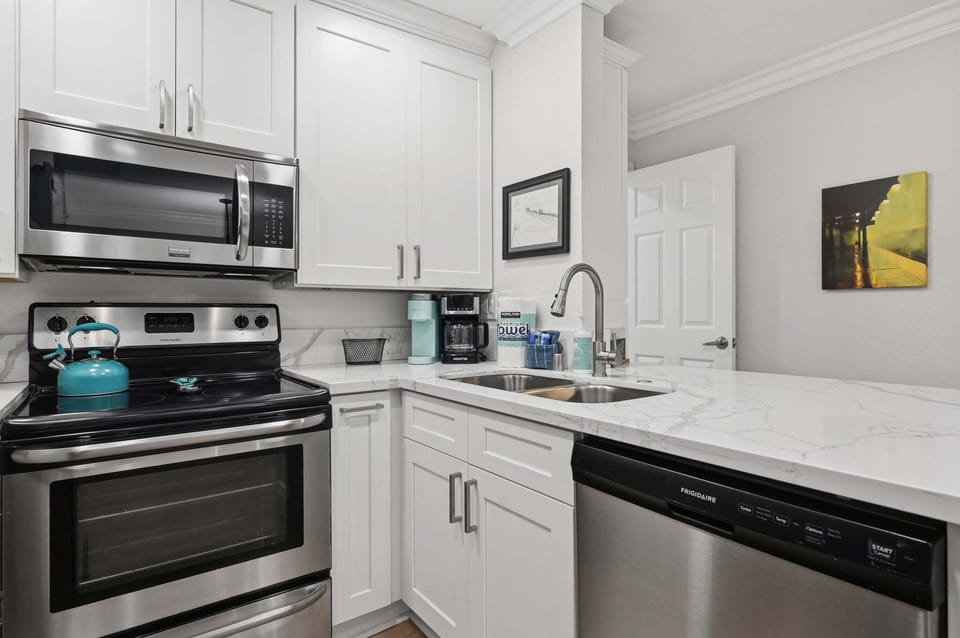 Sleek stainless steel meets crisp white cabinetry in a fully stocked space perfect for whipping up post-beach feasts.