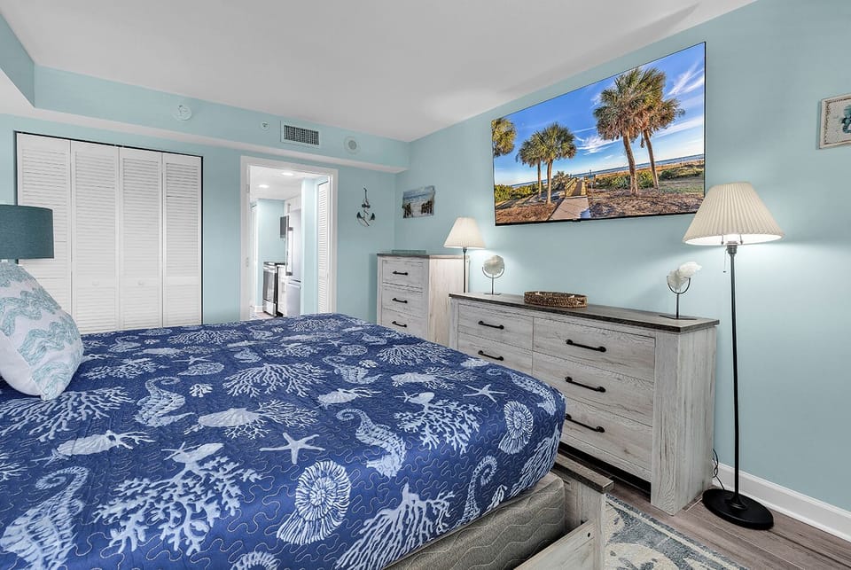 Ocean themed bedroom with a King Sized Bed, 65" Roku TV, two dressers, two night stands, and a closet providing plenty of storage!