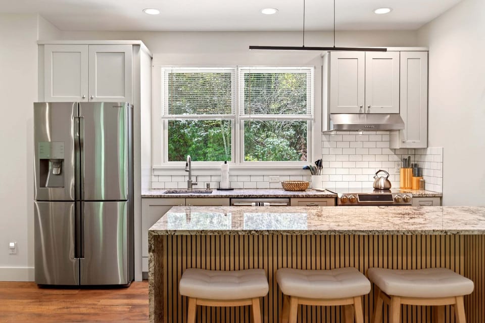 Main kitchen with island seating for 3, dishwasher, drip-style coffee maker, and Keurig coffee maker