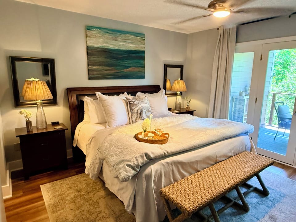 Bright king bedroom with private balcony and serene coastal style