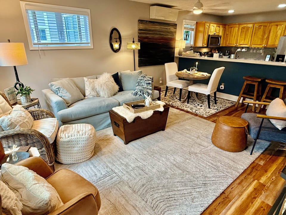 Cozy open living space with stylish seating, dining nook, and breakfast bar