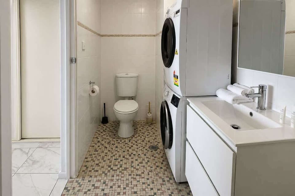 Ensuite bathroom with shower, washer and dryer (no door, curtain in shower)