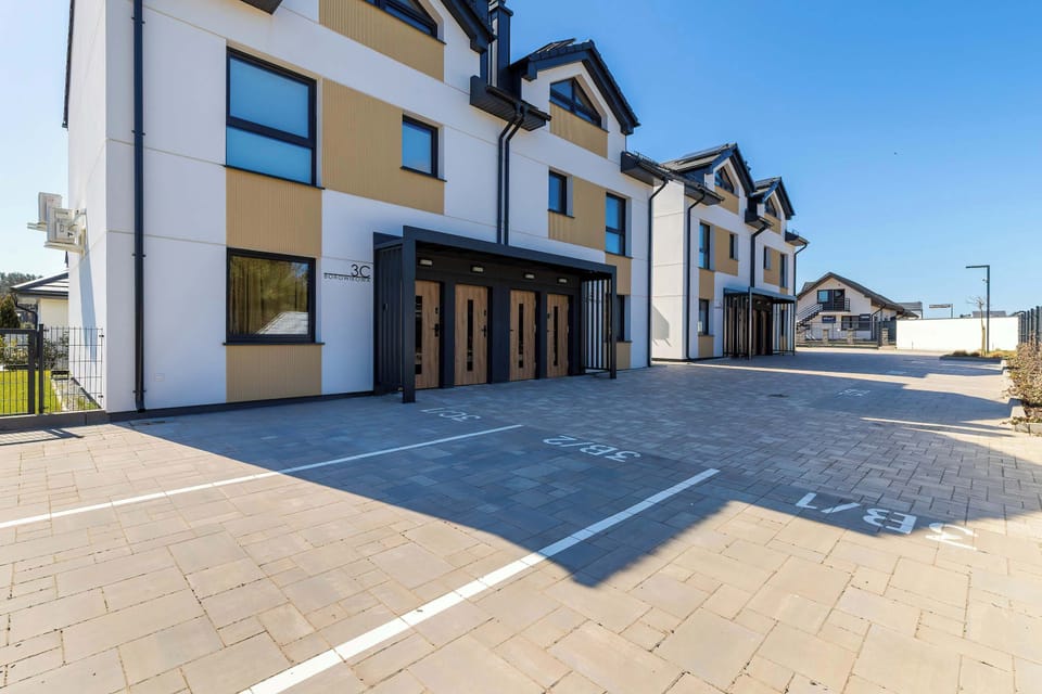 An exterior view of modern apartment buildings with paved streets and clean architecture.

