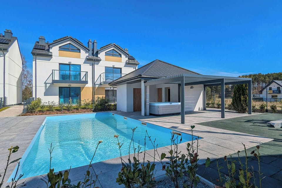 A swimming pool area with surrounding buildings and paved walkways.