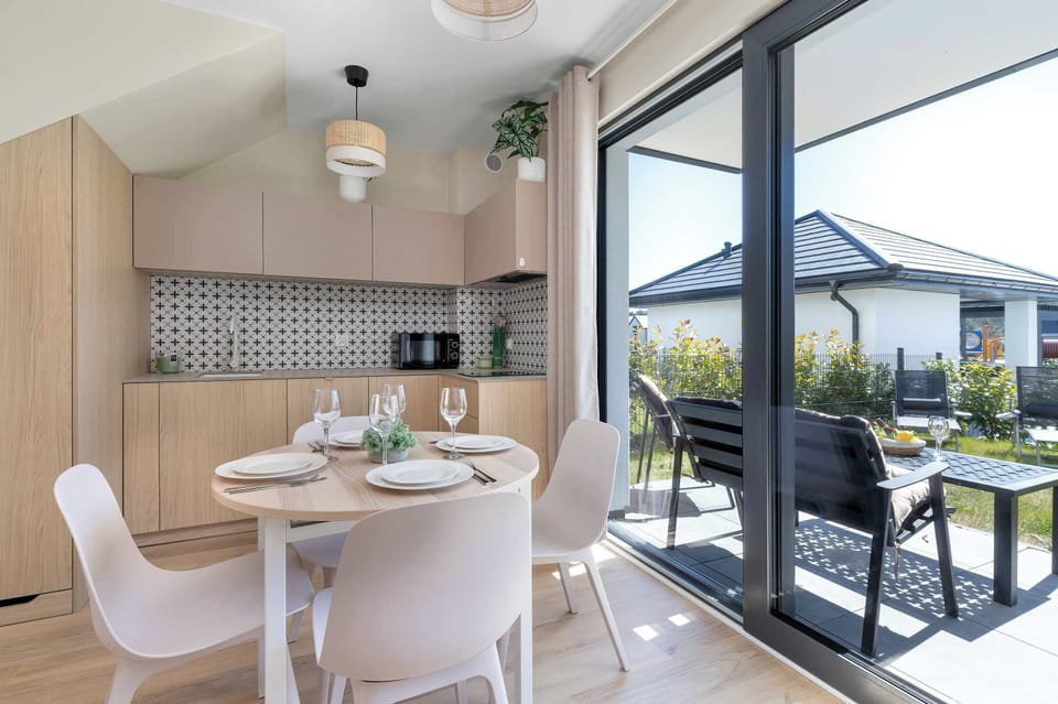 A dining area with chairs and a table placed next to a sliding door leading outside.