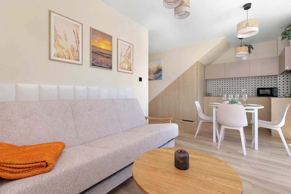 A bright interior with a sofa, dining table, and soft neutral décor.