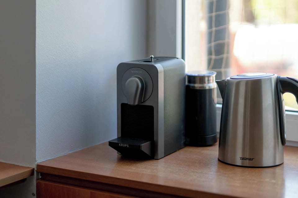 A close-up of a coffee machine and kettle on a countertop. The setup supports convenient daily routines.