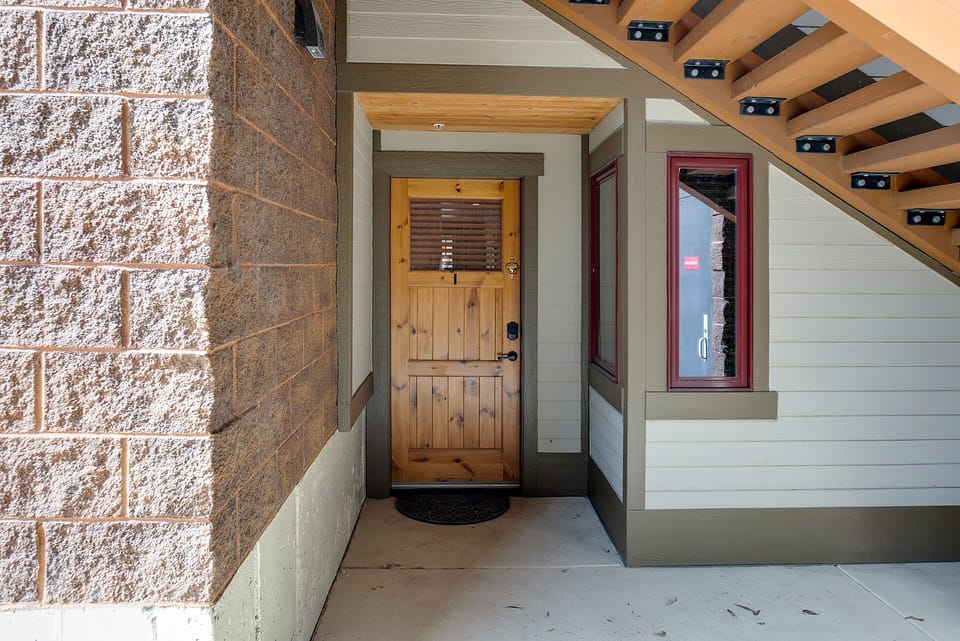 Modern mountain-style entrance with stone accents and natural wood details welcomes guests to this thoughtfully designed retreat.