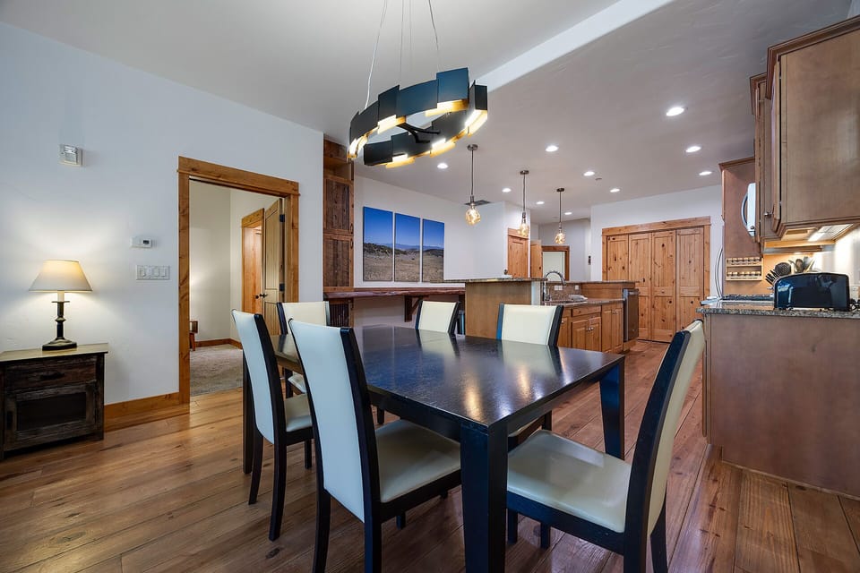 Gather around your elegant dining table for memorable meals in this beautifully appointed space with modern lighting and kitchen access.