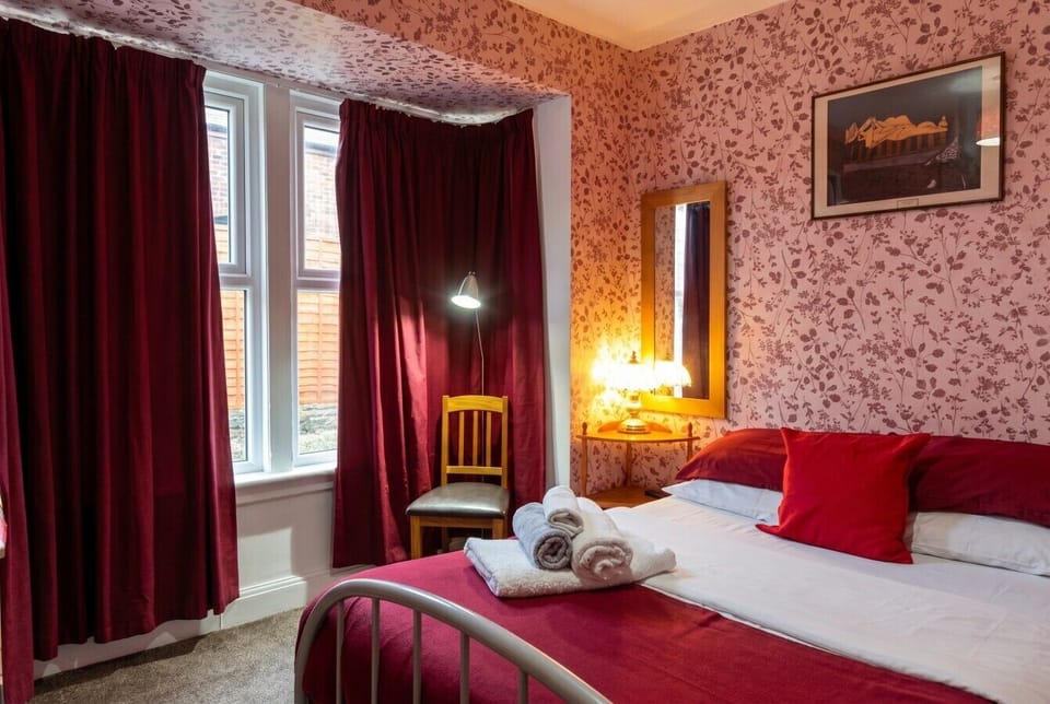 Bold red tones and warm lamplight give this double room real character.