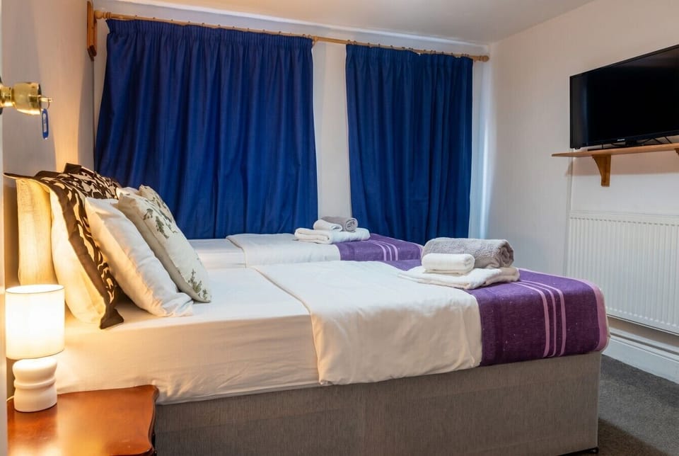 Sink into crisp white bedding with your own TV for a restful night.
