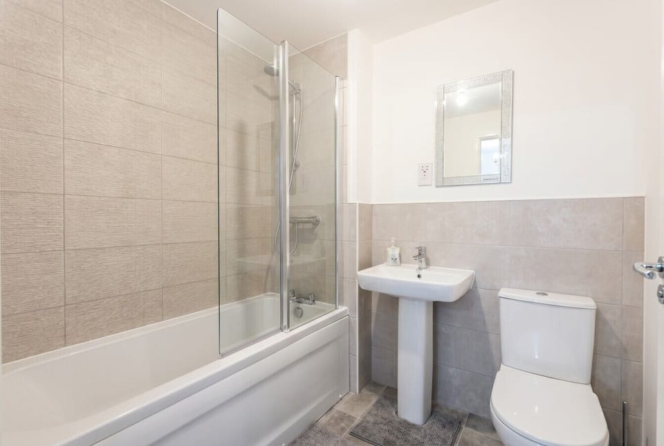 Bright second bathroom with bath and overhead shower, ideal when the house is at full capacity.