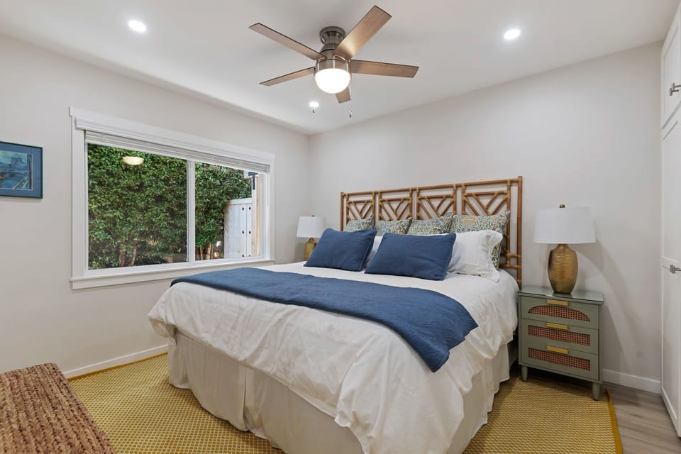 Rest peacefully in your bright bedroom with crisp linens, coastal accents, and a gentle ceiling fan.