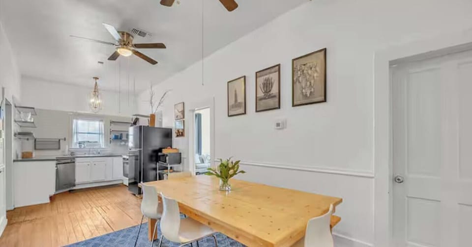 Original exposed beams and a chandelier give the dining space character while the kitchen stays just steps away.