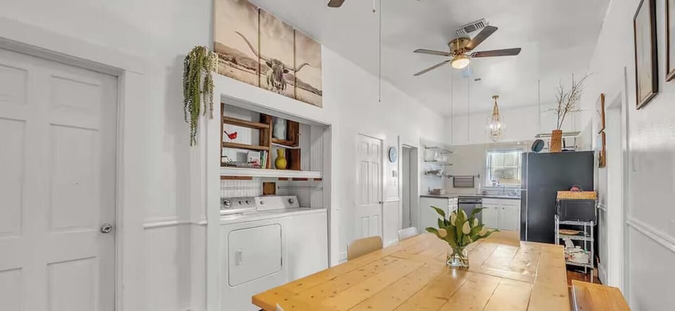 Gather around the long dining table for shared meals, with the in-home laundry nook just steps away.